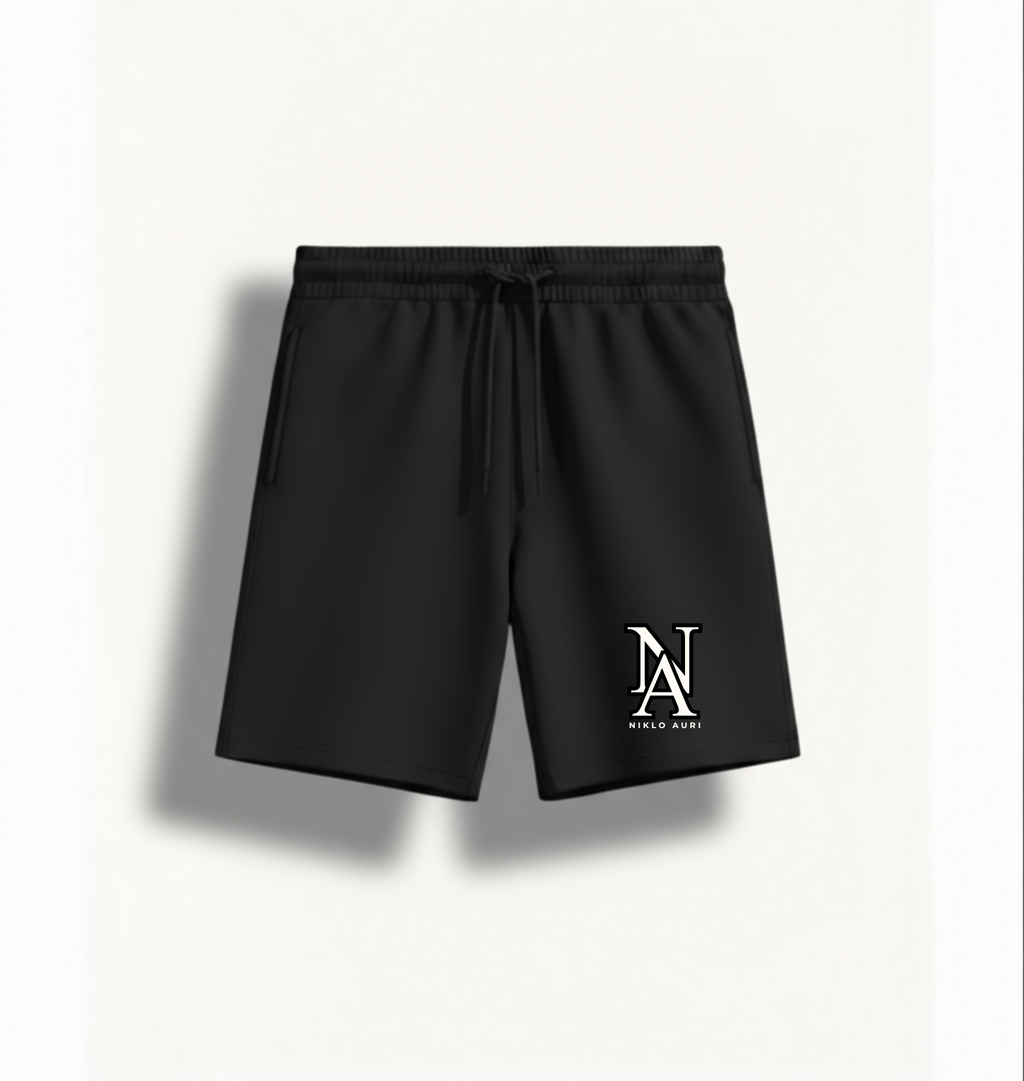 „Niklo Auri Performance Shorts Black – mit weißem NA Monogramm.“