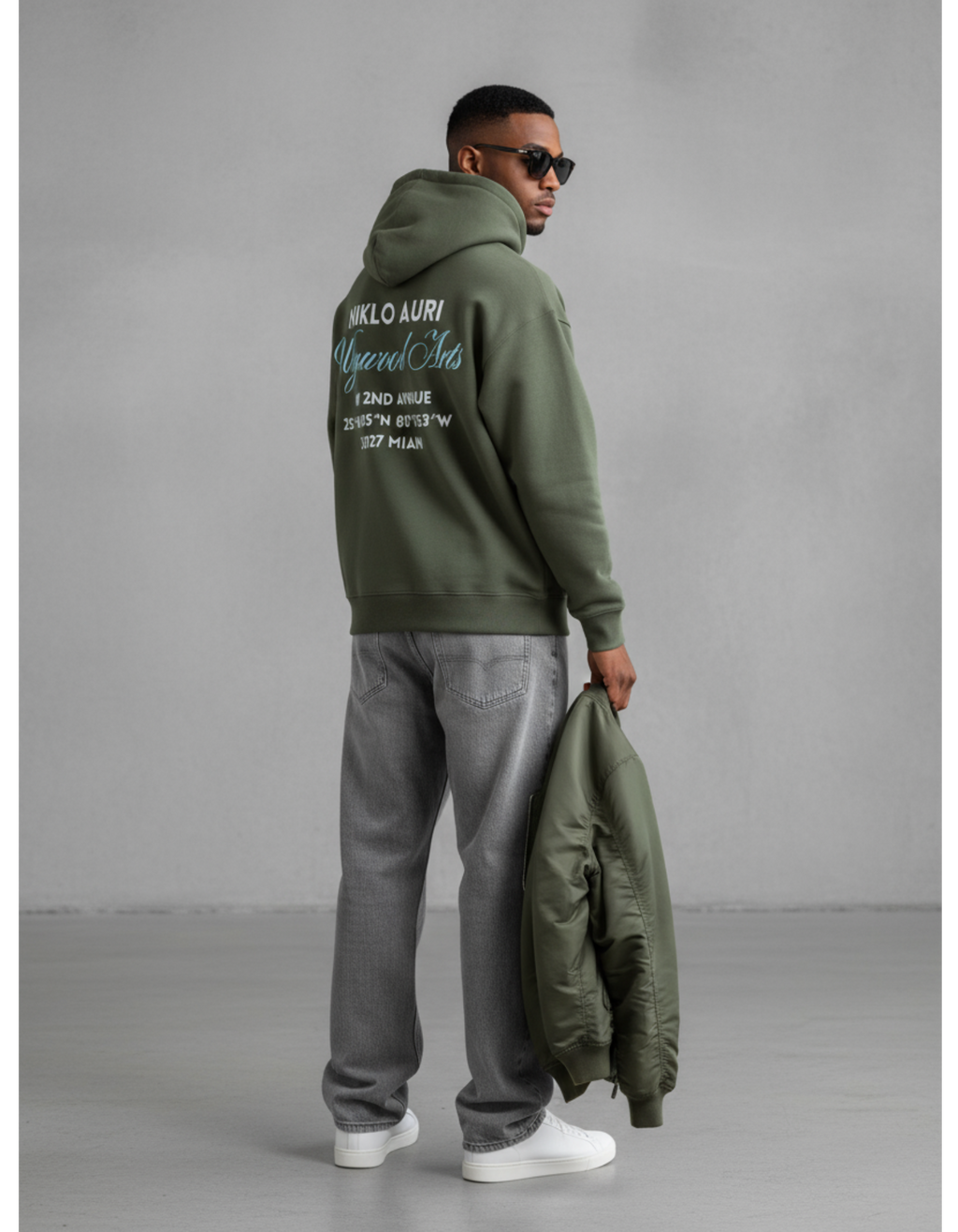 „Model trägt Niklo Auri Upward Arts Hoodie – Miami Edition in Olive Green.“