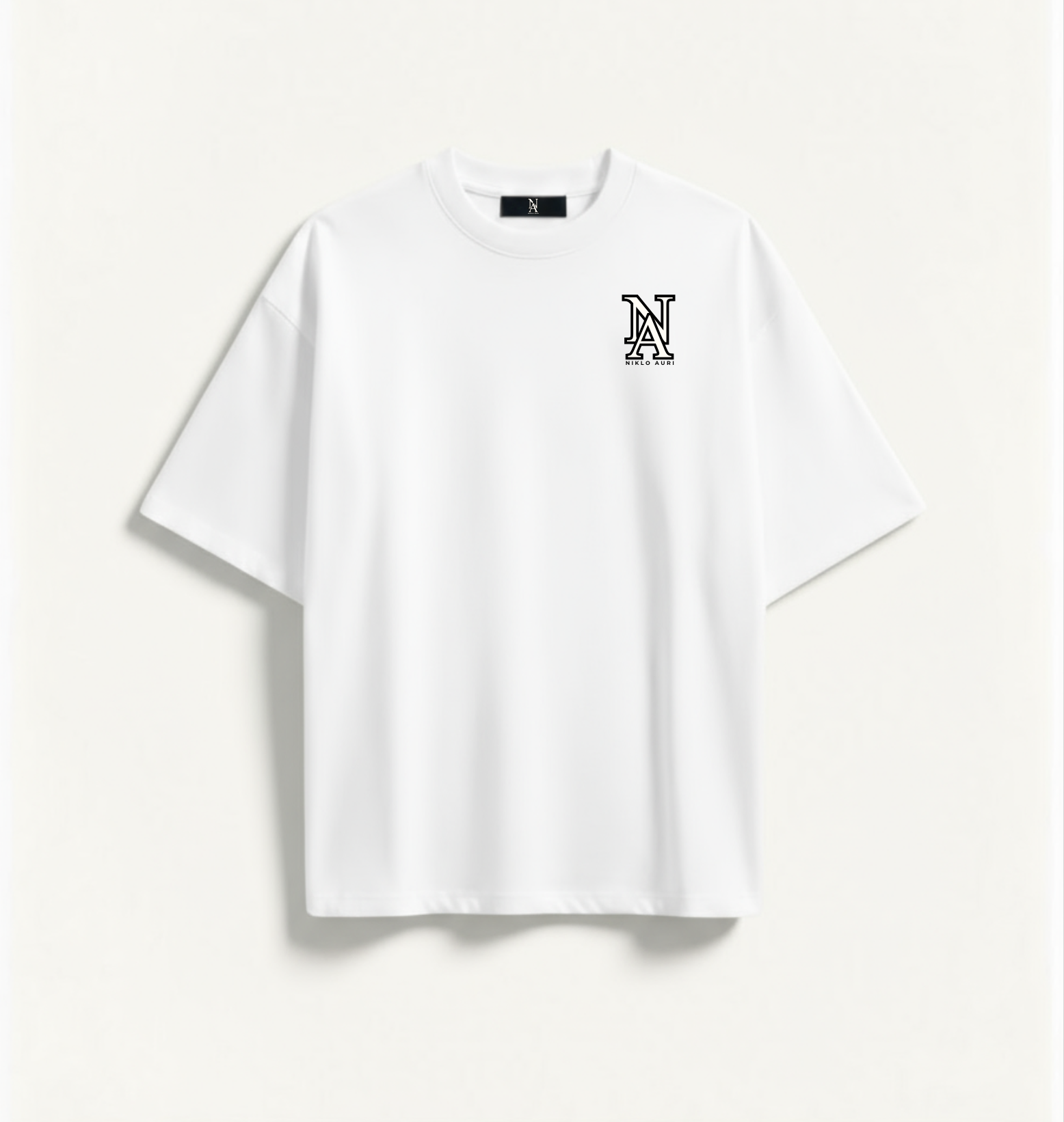 „Vorderseite des weißen Niklo Auri Tees mit NA Monogramm.“